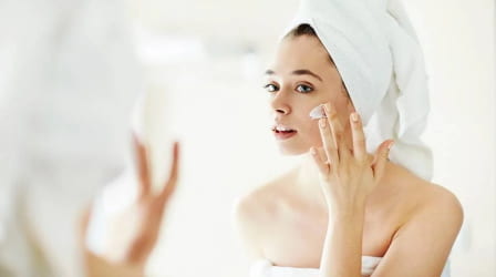 Woman cleansing face